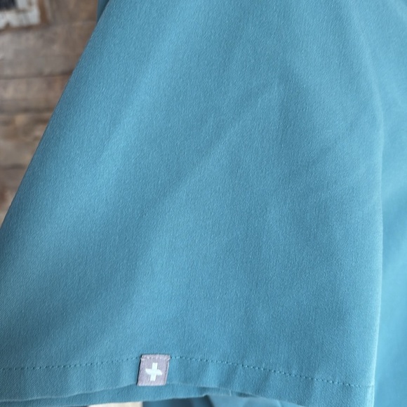 FIGS v-neck short sleeve two front pocket scrub shirt in a blue green color - Picture 6 of 16